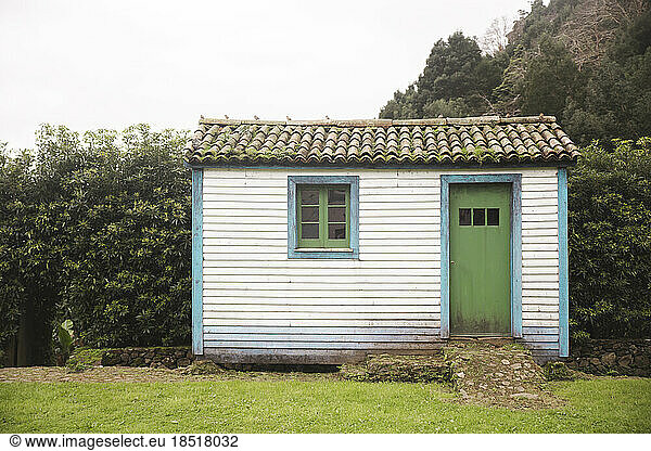 Small wooden house with trees in background