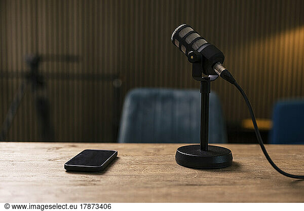 Smart phone by microphone on desk in recording studio