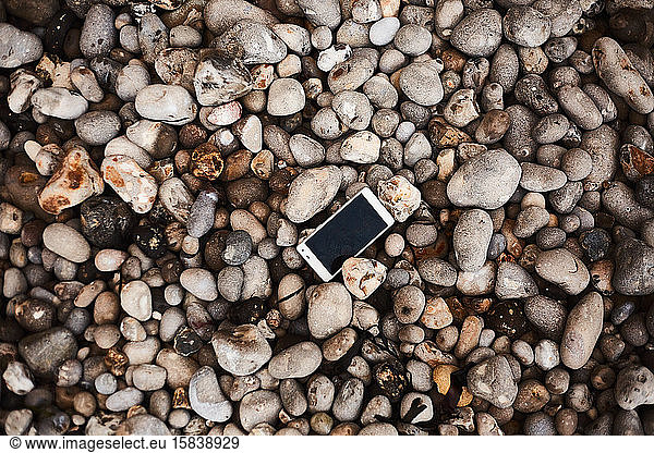 Smartphone laying on the pebble shore