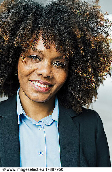 Smiling Afro businesswoman wearing suit