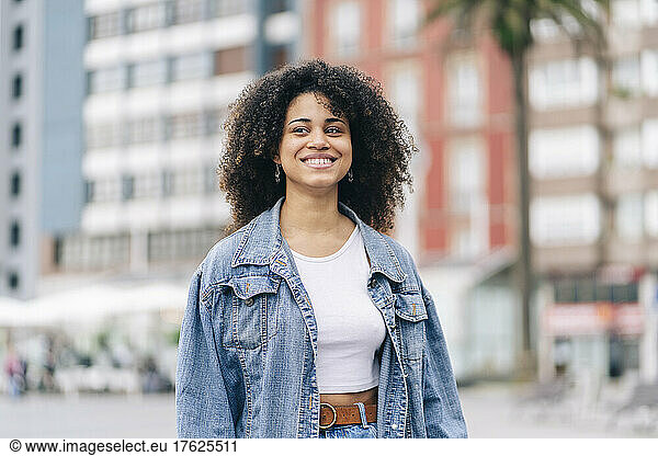 Smiling Afro woman with denim jacket