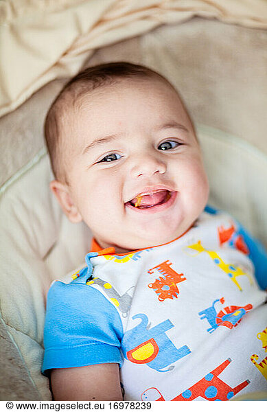 Smiling baby eating his first solid meal