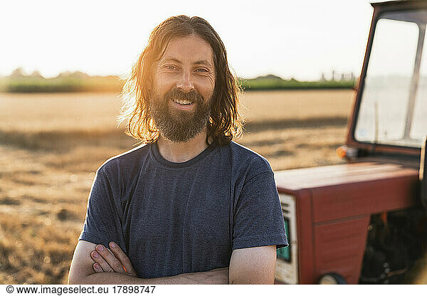 Smiling bearded farmer with arms crossed