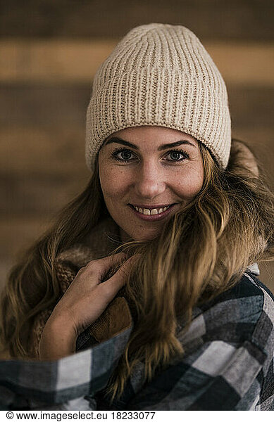 Smiling beautiful blond woman wearing knit hat