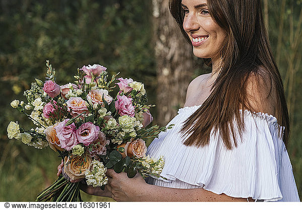 Smiling beautiful woman holding fresh flower bouquet