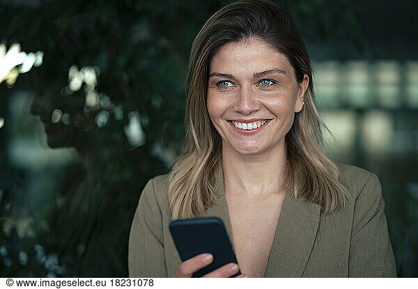 Smiling blond businesswoman with smart phone