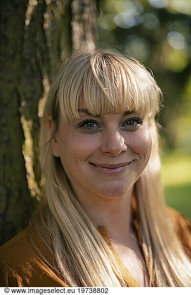 Smiling blond woman in park