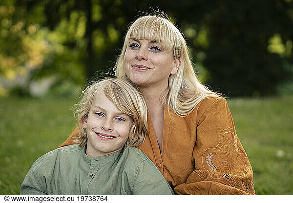 Smiling blond woman with son in park