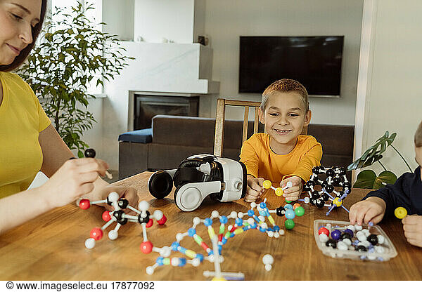 Smiling boy looking at DNA model on table