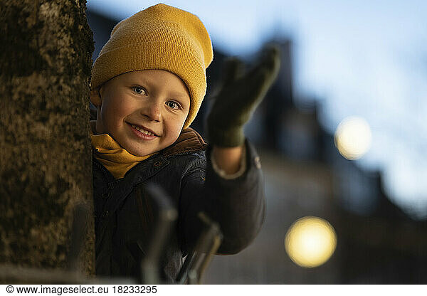 Smiling boy wearing yellow knit hat in winter at night