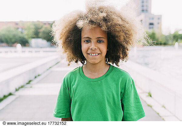 Smiling boy with Afro hairstyle wearing green t-shirt