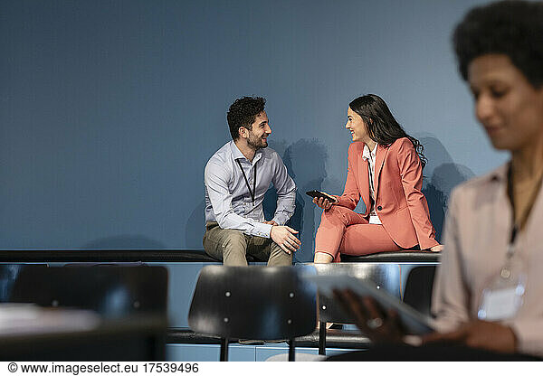Smiling business colleagues discussing in office board room