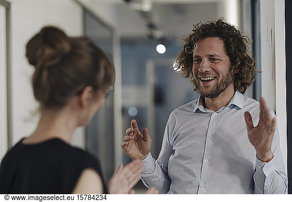 Smiling businessman and businesswoman talking in office