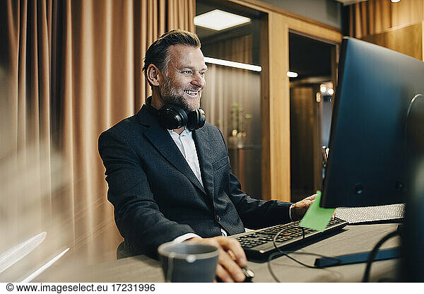 Smiling businessman concentrating while working on computer in office