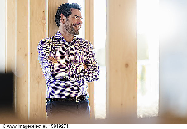 Smiling businessman in wooden open-plan office