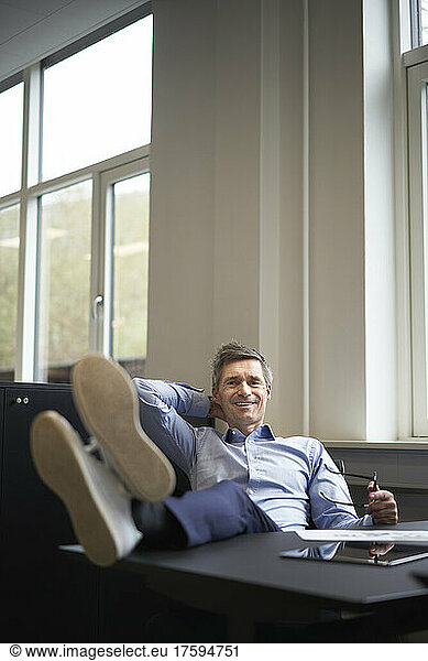 Smiling businessman relaxing in office