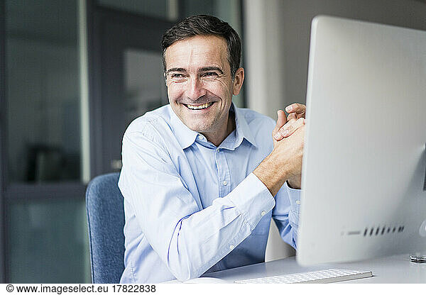 Smiling businessman sitting at desk in office