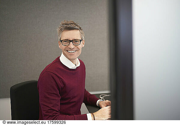 Smiling businessman sitting on chair at office