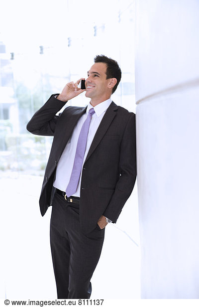 Smiling businessman talking on cell phone