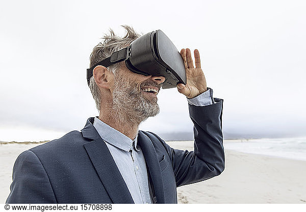 Smiling businessman using VR glasses on the beach  Nordhoek  Western Cape  South Africa