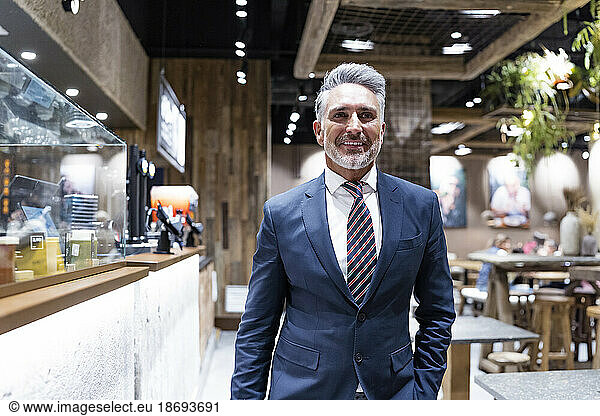 Smiling businessman walking at cafe