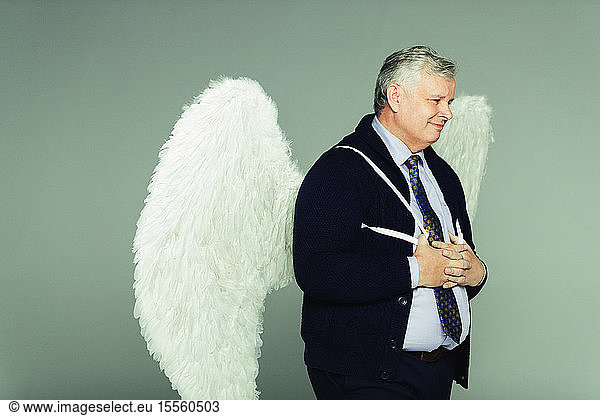 Smiling businessman wearing angel wings