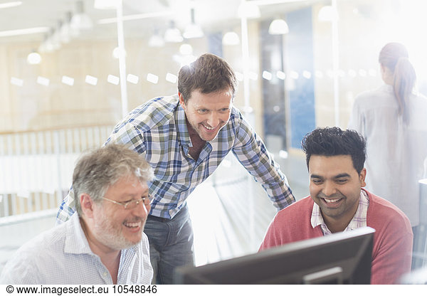 Smiling businessmen working at computer in office