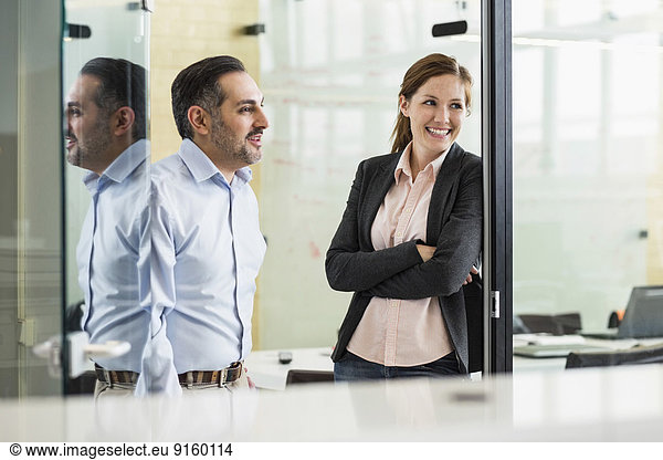 Smiling businesspeople looking away in office