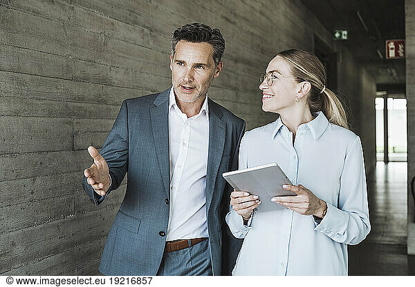 Smiling businesswoman and businessman having discussion together in office