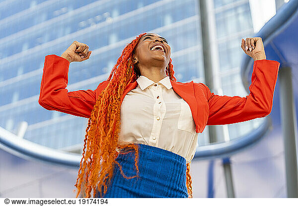 Smiling businesswoman celebrating success in office park