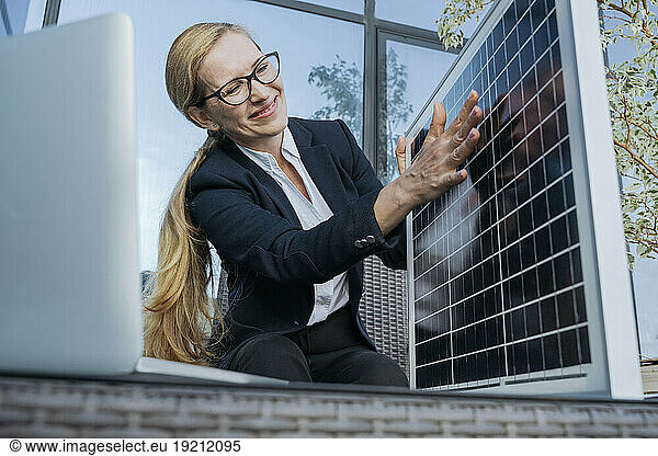 Smiling businesswoman explaining about solar panel over video call on laptop