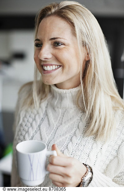 Smiling businesswoman holding coffee mug in office