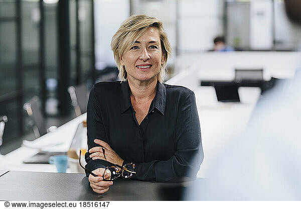 Smiling businesswoman looking at colleague in office