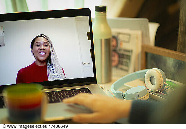 Smiling businesswoman on laptop screen video chatting with colleague