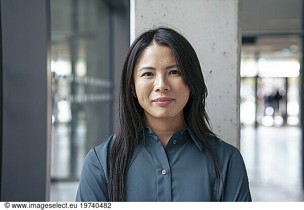 Smiling businesswoman standing in corridor