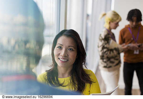 Smiling businesswoman talking with colleague in office