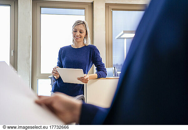 Smiling businesswoman using digital tablet in office