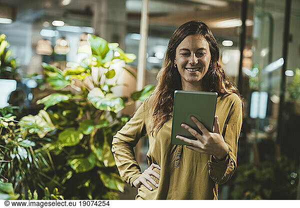 Smiling businesswoman using tablet PC in office