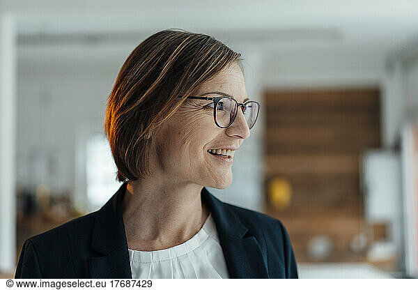 Smiling businesswoman wearing eyeglasses in office