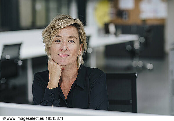 Smiling businesswoman with blond hair sitting in office