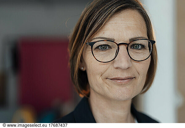 Smiling businesswoman with short brown hair wearing eyeglasses