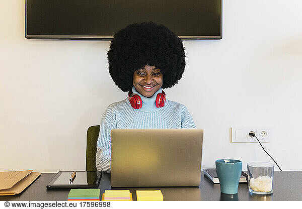 Smiling businesswoman working on laptop at home