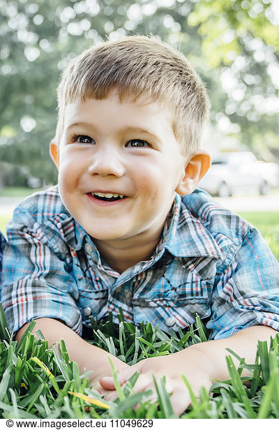 Smiling Caucasian boy posing in grass