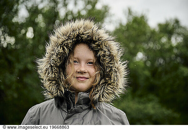 Smiling child in warm coat and hood