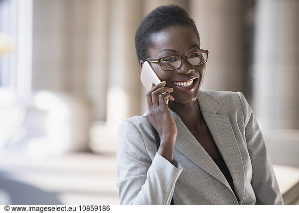 Smiling corporate businesswoman talking on cell phone