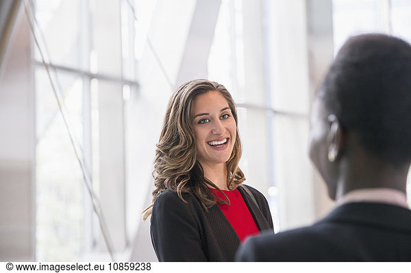 Smiling corporate businesswomen talking