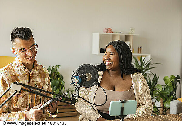 Smiling couple podcasting at home