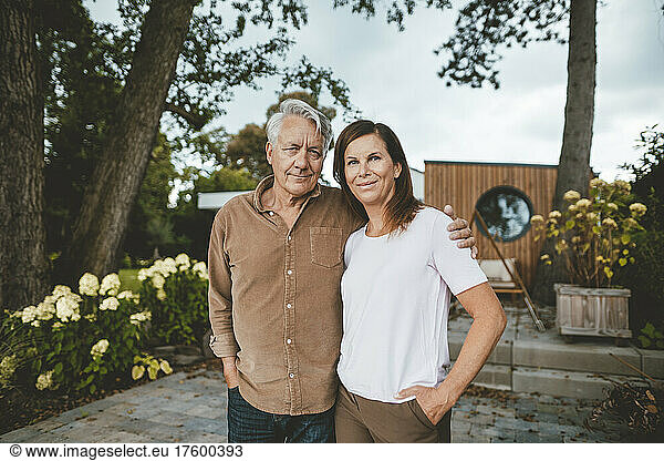 Smiling couple standing together at backyard