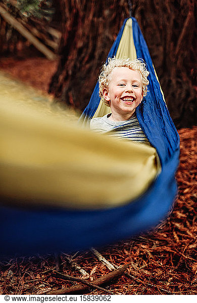 Smiling curly haired child in a hammock