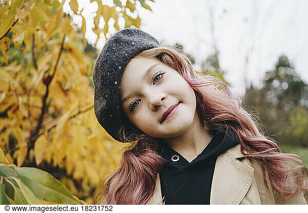 Smiling cute girl standing in autumn park